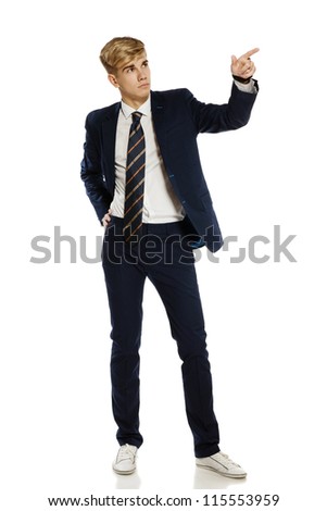 Full length portrait of a stylish young man pointing to the blank copy space, over white background