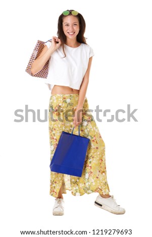 Full length portrait of stylish young asian woman posing with shopping bags against isolated white background 