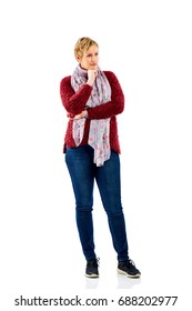 Full Length Portrait Of Thoughtful Mature Woman Standing With Hand On Chin And Looking Away Over White Background