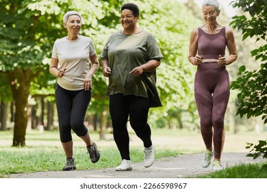 Full length portrait of three active senior women jogging in park together and enjoying sports - Powered by Shutterstock