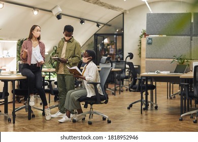 Full Length Portrait Of Three Contemporary Business People Wearing Masks While Discussing Work Project In Modern Office Post Pandemic, Copy Space