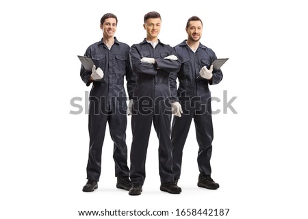 Full length portrait of three mechanic workers in uniforms isolated on white background