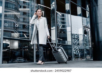 Full length portrait of traveling young business woman with suitcase go walk outside at international airport terminal. Air flight business trip concept. - Powered by Shutterstock