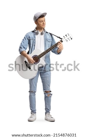 Full length portrait of a trendy guy playing a white acoustic guitar isolated on white background