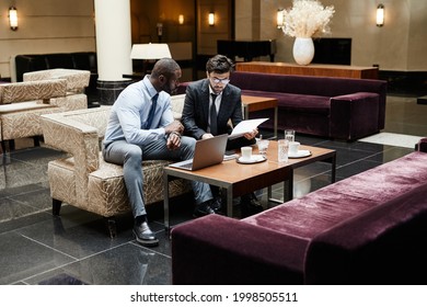 Full Length Portrait Of Two Business People Discussing Work During Meeting At Luxurious Hotel Lobby, Copy Space