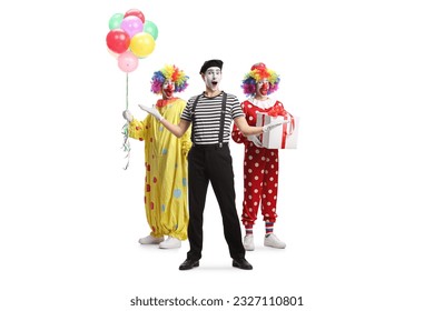 Full length portrait of two clowns and a mime posing isolated on white background