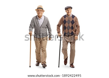 Full length portrait of two elderly men with canes walking towards camera isolated on white background