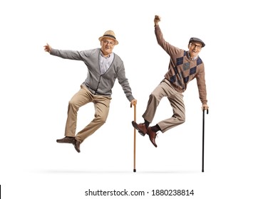 Full length portrait of two excited elderly men with walking canes jumping with joy isolated on white background
