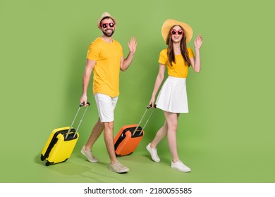 Full Length Portrait Of Two People Walking Arm Palm Waving Hi Bye Isolated On Green Color Background