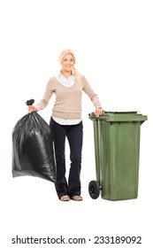 Full Length Portrait Of A Woman Holding A Trash Bag Next To A Garbage Bin Isolated On White Background