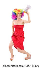 Full length portrait of a woman with wig shouting on a megaphone isolated on white background