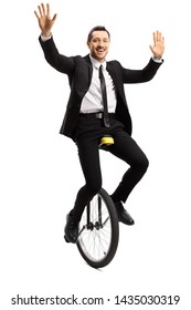 Full Length Portrait Of A Young Businessman In A Suit Riding A Unicycle And Waving With Both Hands Isolated On White Background