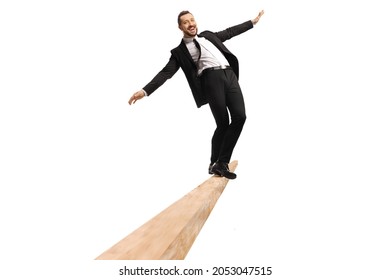 Full length portrait of a young businessman standing on the edge of a wooden beam isolated on white background - Powered by Shutterstock