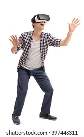 Full length portrait of  young excited man experiencing virtual reality isolated on white background