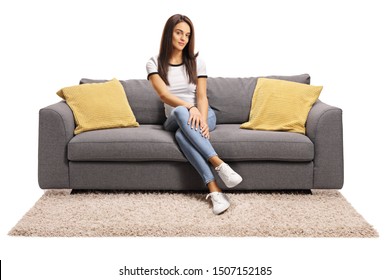 Full Length Portrait Of A Young Female Sitting On Couch With Legs Crossed Isolated On White Background