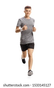 Full length portrait of a young guy jogging towards the camera isolated on white background