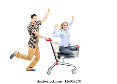 Full length portrait of a young man pushing a woman in a shopping cart isolated on white background - Shutterstock ID 126062378