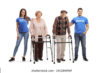 Full Length Portrait Of A Young Man And Woman Volunteering And Helping Seniors With Walkers Isolated On White Background