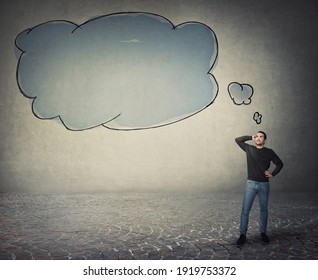 Full Length Portrait Of Young Man, Hand To Nape, Thoughtful Looking Up As Empty Thought Bubble, Thinking Cloud, Comes Out Of His Head. Puzzled Guy Reflecting, Planning His Actions Thinking For Answers