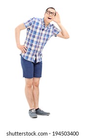 Full Length Portrait Of A Young Man Trying To Hear Something Isolated On White Background