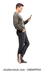 Full Length Portrait Of A Young Man Texting On His Cell Phone Isolated On White Background