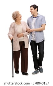 Full Length Portrait Of A Young Man Helping A Mature Woman With A Walking Cane Isolated On White Background