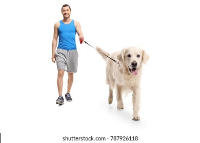 Full Length Portrait Of A Young Man In Sportswear Walking A Dog Isolated On White Background