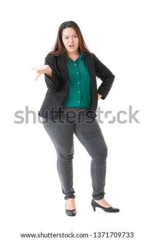 Full length portrait of young, plump, beautiful, Asian lady, in smart casual, green shirt, black pants, spread hand, annoyed, making who cares gesture, on isolated white background