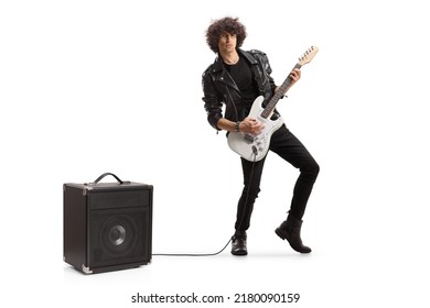 Full length portrait of a young rock musician playing a guitar plugged into an amplifier isolated on white background - Shutterstock ID 2180090159