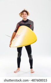 Full Length Portrait Of A Young Smiling Surfer Holding Surf Board Isolated On The White Background