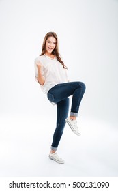 Full Length Portrait Of A Young Woman Celebrating Her Success Isolated On A White Background