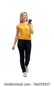 Full Length Portrait Of A Young Woman Walking And Using A Phone Isolated On White Background