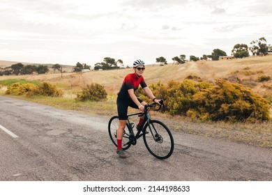 Full Length Of A Pro Cyclist Taking A Break From Intense Training On Country Road