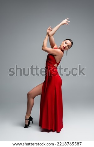 Full length of professional ballroom dancer moving on grey background