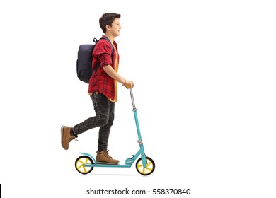 Full Length Profile Of A Happy Kid Riding A Scooter Isolated On White Background