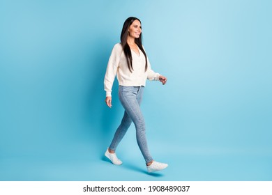 Full length profile photo of adorable lady beaming smile walking isolated on pastel blue color background