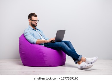 Full length profile photo of attractive guy holding notebook browsing chatting colleagues sitting comfy soft armchair wear specs casual denim outfit isolated grey color background - Powered by Shutterstock