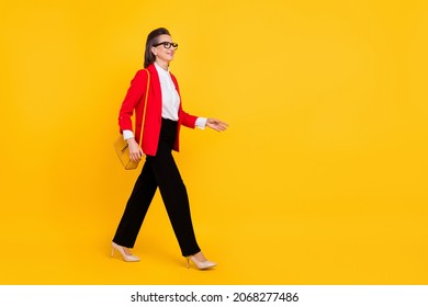 Full Length Profile Photo Of Cool Aged Woman Go Wear Cardigan Pants Stilettos Isolated On Yellow Background