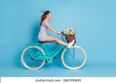 Full Length Profile Photo Of Crazy Girl Drive Bike Raise Legs Wear Dotted Short Dress Footwear Isolated Blue Color Background