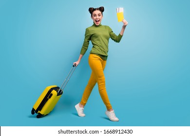 Full Length Profile Photo Of Funny Pretty Lady Hold Tickets Passport Cheap Flight Rolling Suitcase Walk Airport Wear Green Turtleneck Yellow Pants Footwear Isolated Blue Color Background