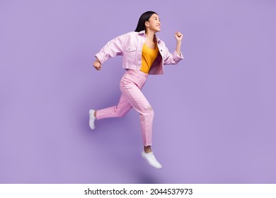 Full length profile photo of funny young brunette lady run wear jacket jeans sneakers isolated on violet background - Shutterstock ID 2044537973