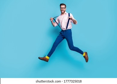 Full length profile photo of handsome business man jump high shopping center running crazy addicted shopaholic wear specs shirt suspenders pants boots isolated blue color background - Shutterstock ID 1777325018