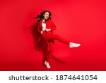 Full length profile photo of lovely young girl dance open mouth raise leg wear jacket trousers footwear isolated red color background