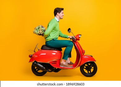 Full Length Profile Photo Of Nice Guy Driving Bike Hold Flower Behind Back Wear Sweater Isolated On Yellow Color Background