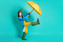 Full Length Profile Photo Of Shocked Lady Stormy Rainy Weather Walk Street Hold Umbrella Catch Strong Wind Blew Away Wear Raincoat Sweater Pants Gumboots Isolated Teal Color Background