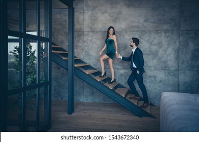 Full length profile photo of tender stylish trendy couple guy lady erotic desire climbing up second floor holding hands new house excursion wear formalwear suit short dress loft industrial indoors