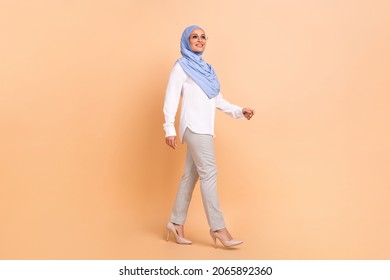 Full Length Profile Photo Of Young Arabic Modern Lady Go Wear Headscarf Shirt Eyewear Pants Stilettos Isolated On Peach Background