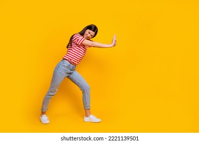 Full length profile portrait of hardworking pretty lady closed eyes arms push empty space isolated on yellow color background