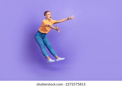 Full length profile portrait of impressed person jump fall arms catch empty space isolated on purple color background