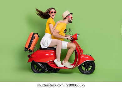Full length profile portrait of two excited partners drive moped adventure isolated on green color background